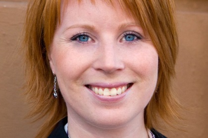 Annie Lööf har axellångt rödblont hår och blå ögon.