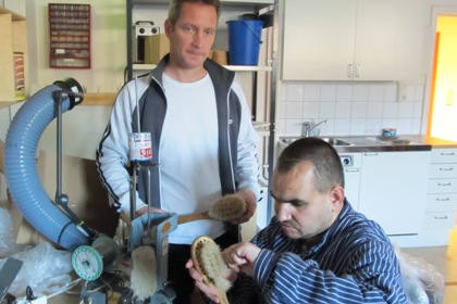 Produktionschef Richard Sparrenhök är iklädd t-shirt och en öppen jacka. Han har kortklippt hår. Bredvid sitter Turkut Semirkiran han har kortsnaggat hår och bär en blåvit murarskjorta.