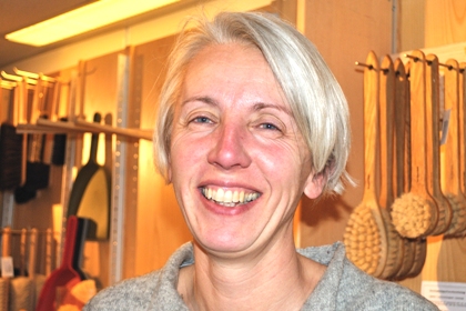Friedrike Roedenbeck står leende framför en vägg täckt av borstar.