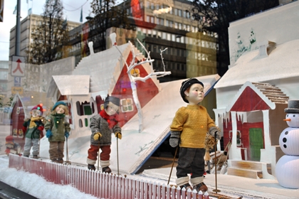 Vinterklädda dockor åker skidor i ett snöigt sagolandskap i NK:s skyltfönster.