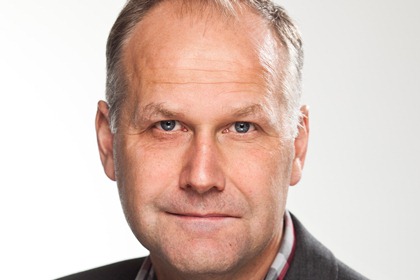 Jonas Sjöstedt är blong med tunnare hår högst upp, lite gråhårig vid tinningarna och har blå ögon.
