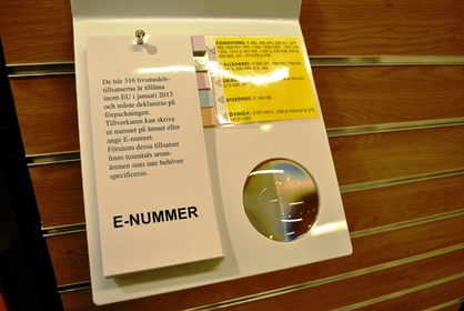 Bild på vit skiva med förstoringslins i, samt katalog med e-nummer.